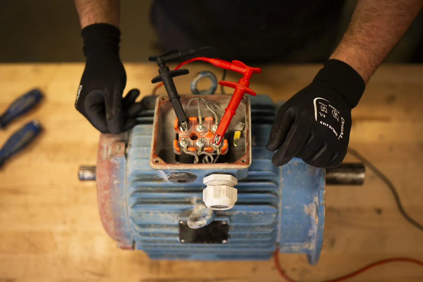 Technicien de l'atelier TCA mesurant l'isolement d'un moteur électrique bleu au mégohmmètre à Clermont-Ferrand